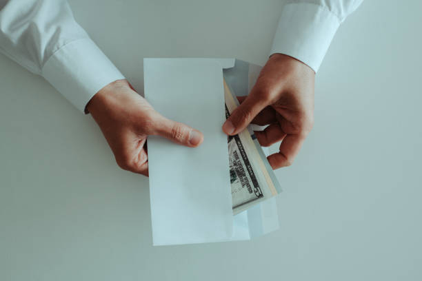 istock man taking out a bunch of dollars from an envelope 1488354047