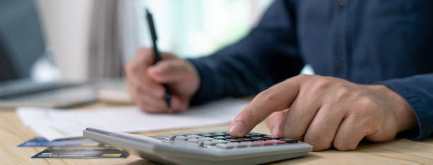 istock Accountant working with a calculator. Financial advisors analyze income and trends from documents and expense bills. 1488354109