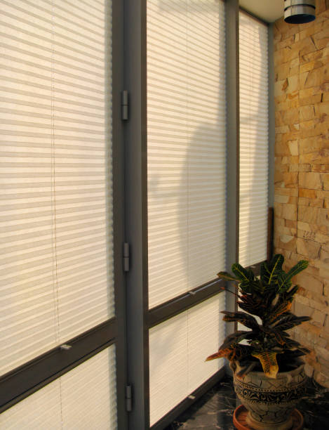 istock Pleated blinds with beige folded fabric on the windows close-up. 1488355391
