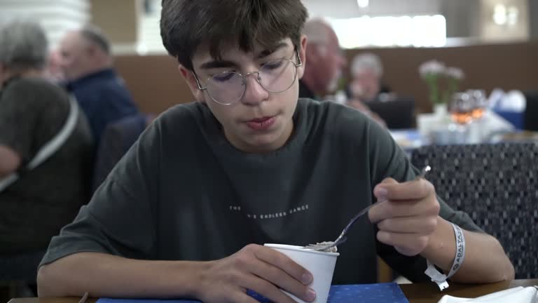 Young boy eating ice cream in hotel restaurant