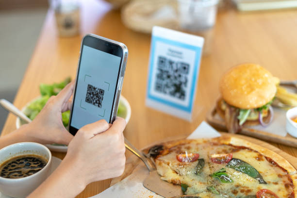 istock Woman's hand uses a phone to scan a qr code in a restaurant to receive a discount or pay for food.  Use phone to transfer money or pay online without cash. 1488357471