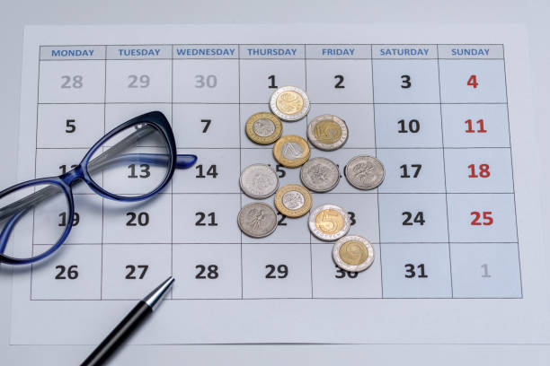 página de calendario mensual con monedas polacas, gafas - interest rate finance financial page financial figures fotografías e imágenes de stock