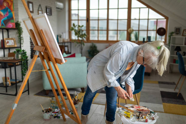 집에서 팔레트에 페인트를 칠하는 노인 - painted image paintings oil paint senior women 뉴스 사진 이미지