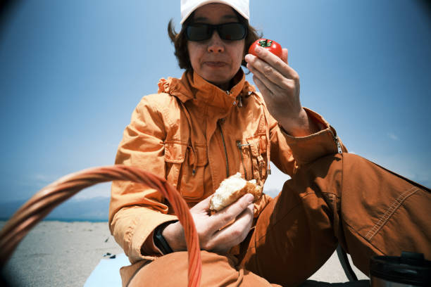 istock Female backpacker is having a picnic on mountain lake 1488359025