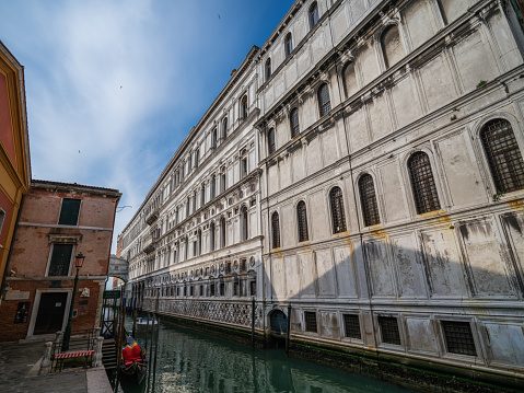 Venice, Italy - April 23, 2023: High resolution. East side of the Doge's Palace with a glimpse of the Bridge of Sighs leading to the prison on the other side of the canal.