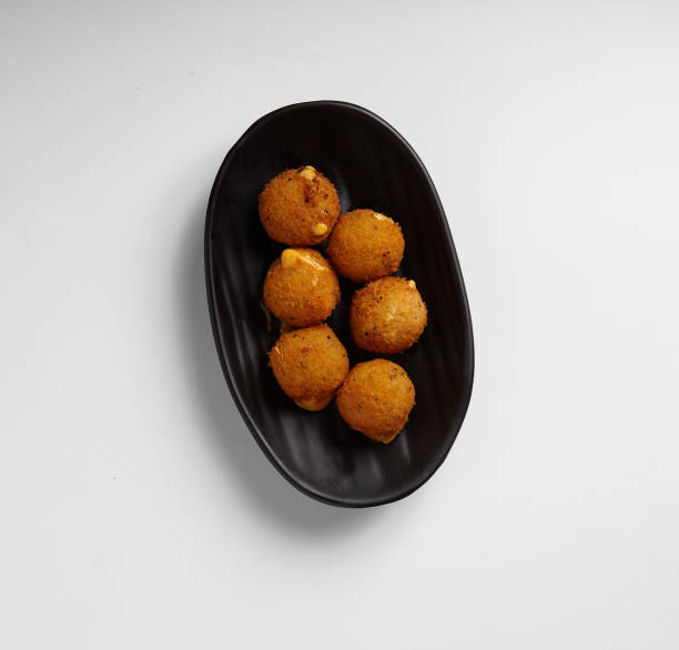 istock Fried Cheese Balls on a Black Plate White Background Studio Shot 1488365689