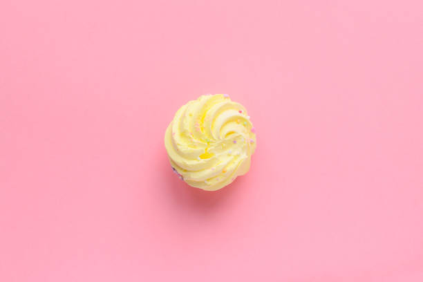 istock Single delicious yellow meringues on pink background copy space 1488365701