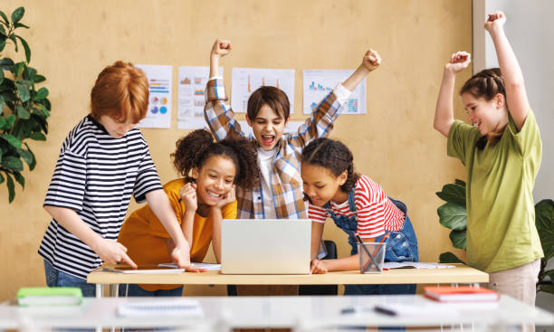 istock Cheerful  schoolkids   looking at laptop screen and celebrate   successful completion of collective school work   during online lesson 1488367340