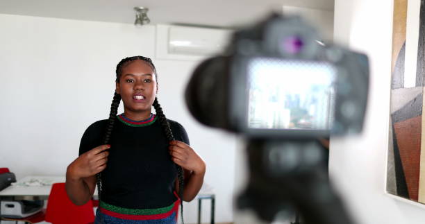 istock Young woman vlogging in front of camera tripod 1488368933