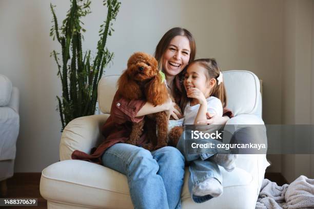 Young Woman And Her Daughter With Of Apricot Puddles Meet In The Morning In Sofa Stock Photo - Download Image Now