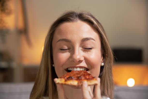 istock Blonde young woman eating pizza 1488371981