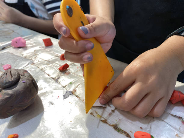 istock close up hands child cutting clay for sculpture. 1488373653