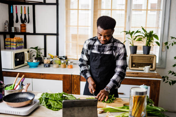 istock Young man cutting vegetables for healthy meal 1488375045