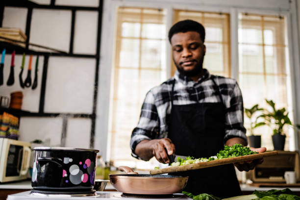 istock Man puts vegetables in pan for frying 1488375180