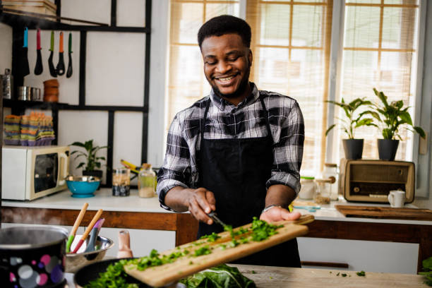 istock Happy man puts vegetables in pan for frying 1488375343