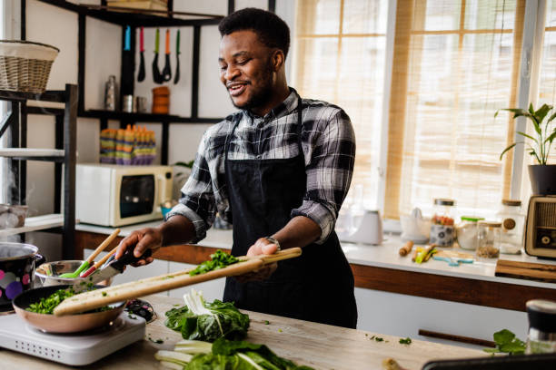 istock Happy young man cooks at home 1488375344