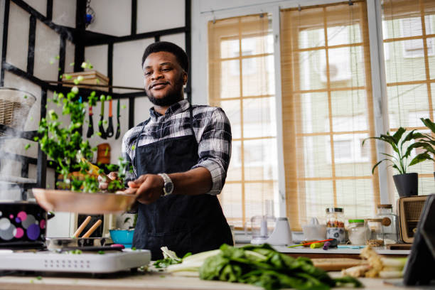 istock Smiling chef throws ingredients in midair while frying 1488375345