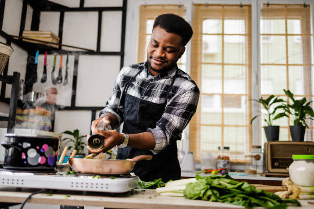 istock Happy young man puts pepper in his meal 1488375369