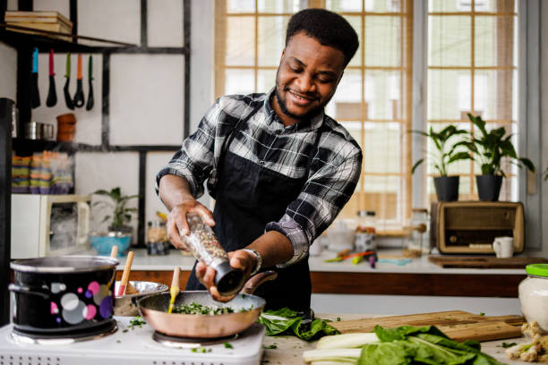 istock Happy man puts spices in frying pan 1488375393