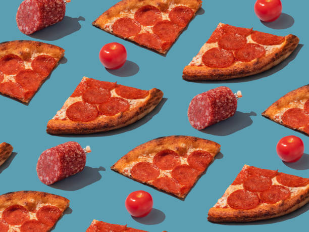 istock Pepperoni slice pizza with salami and tomatoes pattern. Food pattern with hard shadows 1488376178