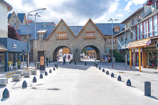 Some people are strolling in the Civic Center of Bariloche with its characteristic buildings.
