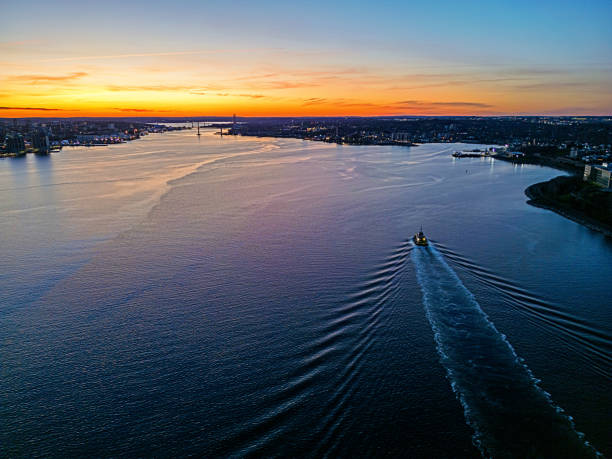 Aerial view of a tugboat heading back to its dock.
