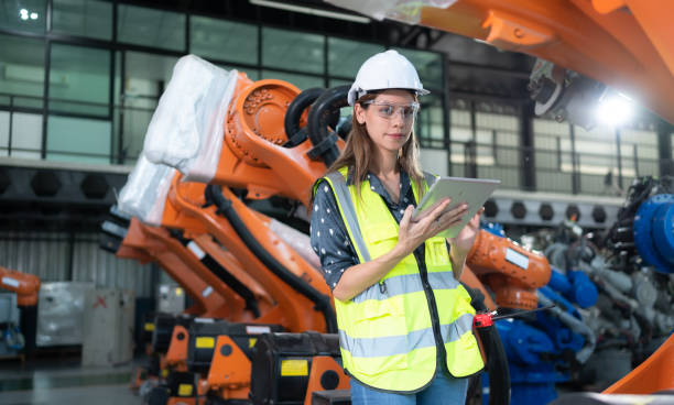 istock A female engineer installs a program on a robotics arm in a robot warehouse. And test the operation before sending the machine to the customer. 1488380705