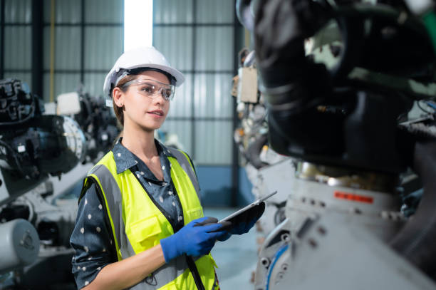 istock A female engineer installs a program on a robotics arm in a robot warehouse. And test the operation before sending the machine to the customer. 1488380888