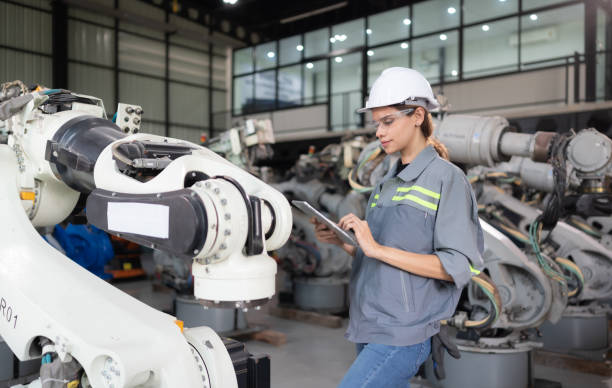 istock A female engineer installs a program on a robotics arm in a robot warehouse. And test the operation before sending the machine to the customer. 1488381439