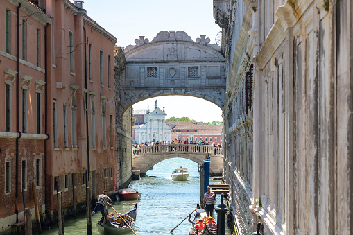 Venice, Italy : 2023, April 27 - Gondoliers transport their guests through the narrow streets of Venice, Bridge of Sighs
