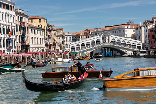 Venice, Italy : 2023, April 27 - Gondoliers transport their guests through the narrow streets of Venice