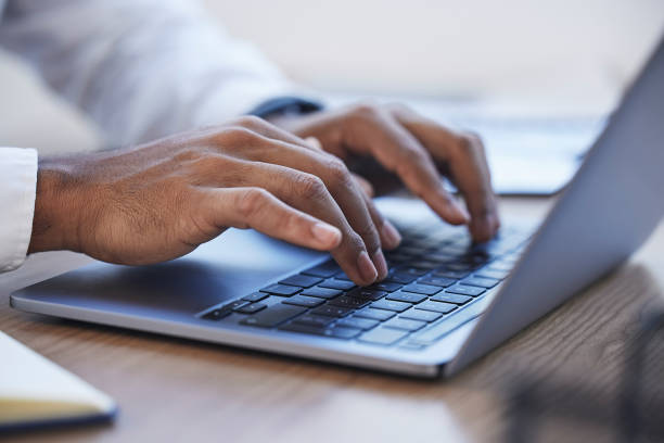istock Laptop, office and hands typing at desk for online documents, writing email and business proposal. Technology, networking and zoom of businessman on computer for research, report and website review 1488389652