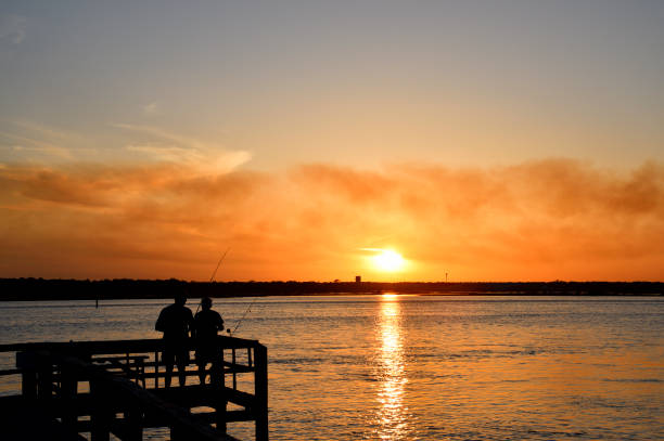 istock People fishing on pier at sunset 1488391129
