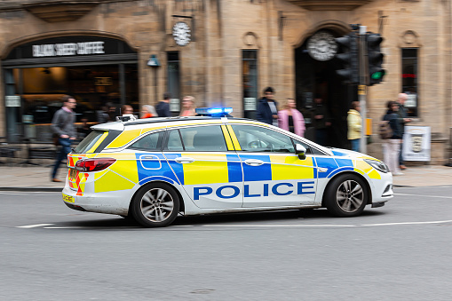 Oxford, UK - April 30, 2023: Police car on blue lights responding to an emergency seen Oxford city centre.
