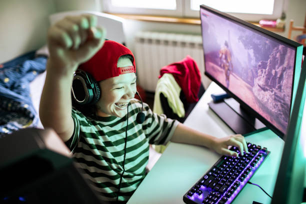 Close up of a Young boy playing videos games on his desktop computer