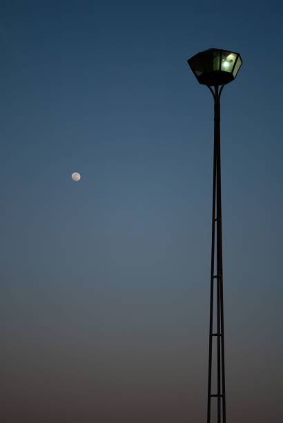 istock a tall lamp post under a clear sky and the moon 1488394091