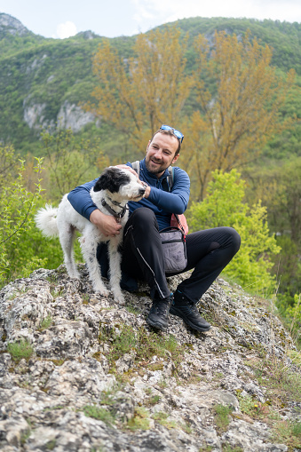 If this isn't loyalty, I don't know what is. Cropped shot of a handsome mature man sitting on a rock with his golden retriever after a day out hiking.