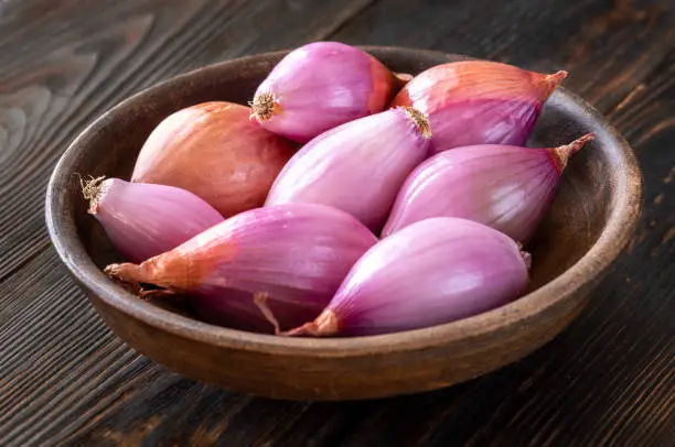 Bowl of shallot onions on the wooden background