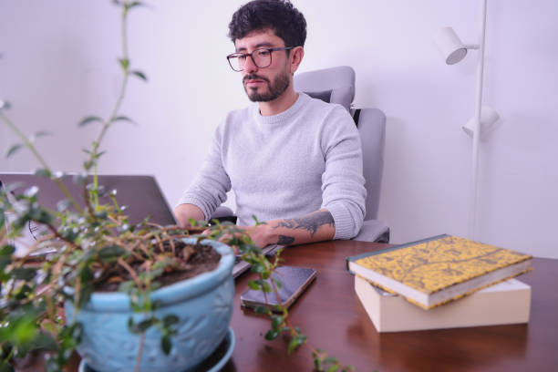 istock tattooed middle aged man studying at home 1488396552