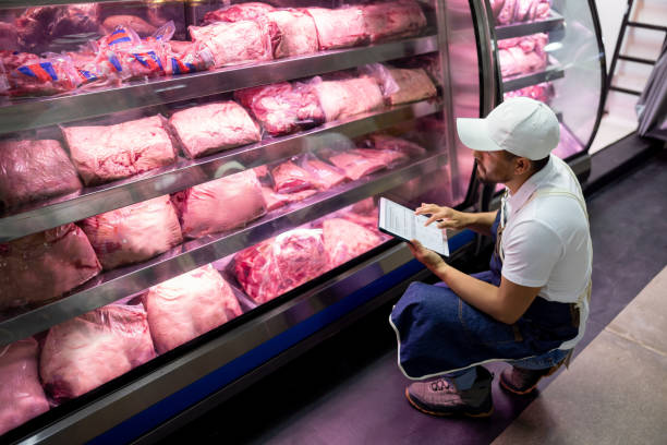 istock Man working at a butcher's shop doing an inventory 1488399904