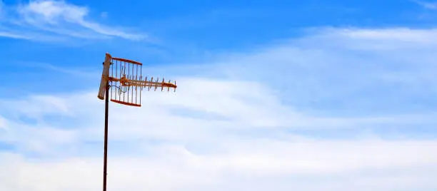 Photo of An  antenna for receiving a radio station or TV programmes on a blue sky background.