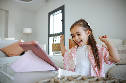 Little girl keeping herself entertained with the online world