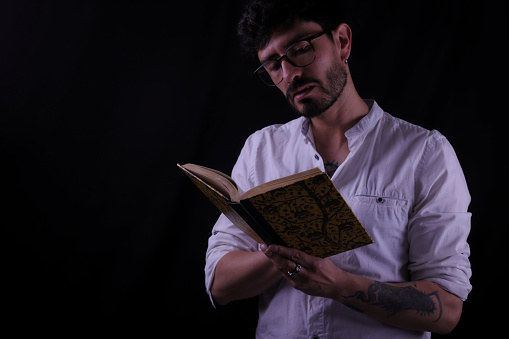 tattooed man reading a book