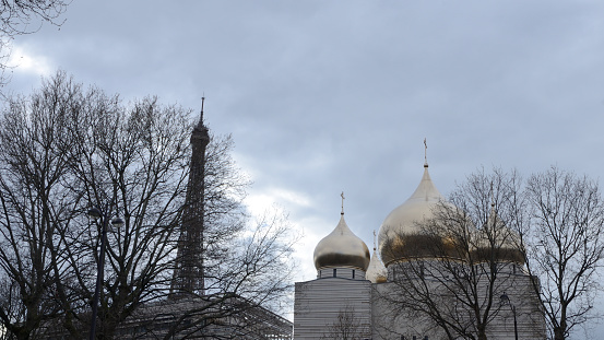 Paris, France - March 19, 2023: The Eiffel Tower behind the Russian Orthodox church  in historical center of Paris, France.