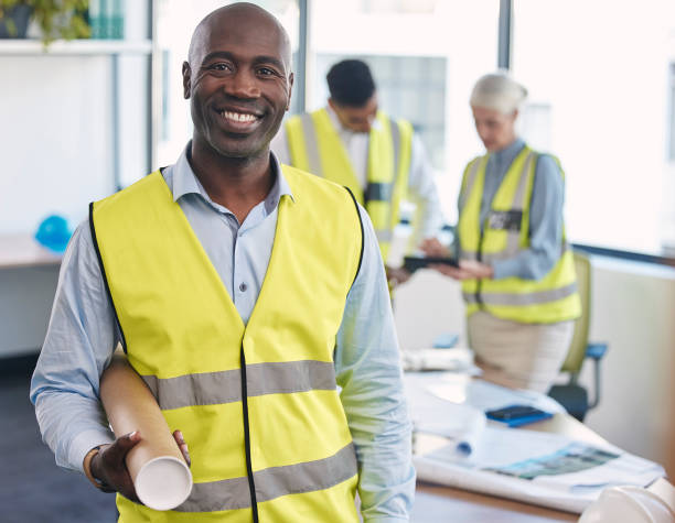 Black man, architect and portrait smile with blueprint for building or construction plan at the office. Happy African American male engineer or contractor smiling with floor plan for architecture