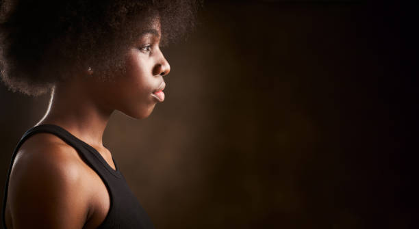 Young ethnic girl with afro hairstyle seen from the side stock photo