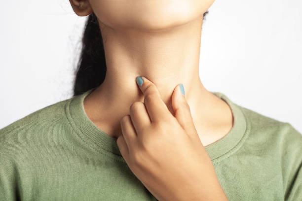 women experiencing throat pain due to tonsil or cold and flu closeup shot of a women suffering from thyroid, tonsil or throat soreness larynx stock pictures, royalty-free photos & images