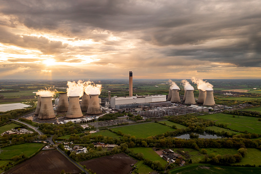 Drax Power Station, Selby, UK - May 5, 2023. Aerial landscape view of Drax Power Station in North Yorkshire with smoking chimneys and cooling towers pumping CO2 into the atmosphere at sunset