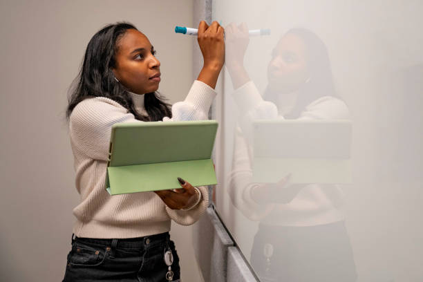 istock African American woman writing on whiteboard holding tablet 1488410068