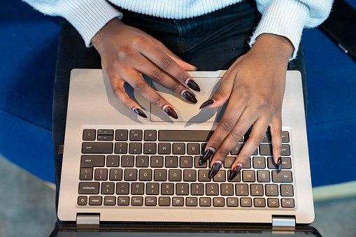 African American woman typing on laptop